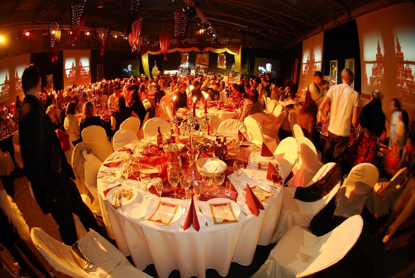 Banquet hall — round tables, white linens, red napkins, candelabra centerpieces